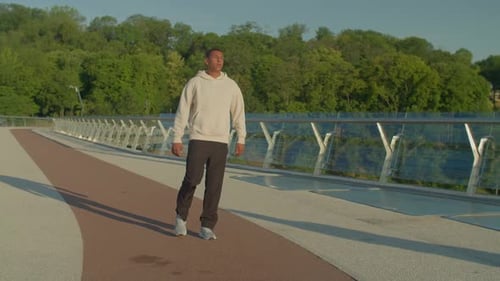 Man Stretching Legs on City Pedestrian Bridge