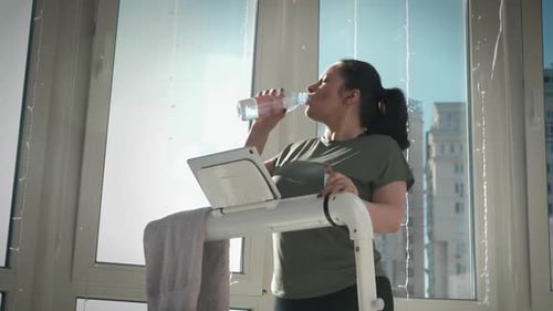 Woman Drinking Water during Workout at Home