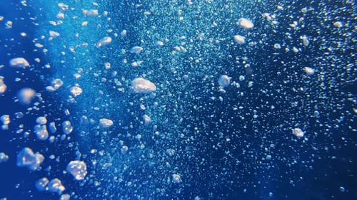Bubbles Rising Underwater in Deep Blue Ocean