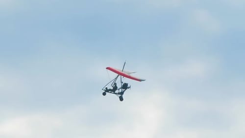 Hang Glider Flies Through Blue Sky