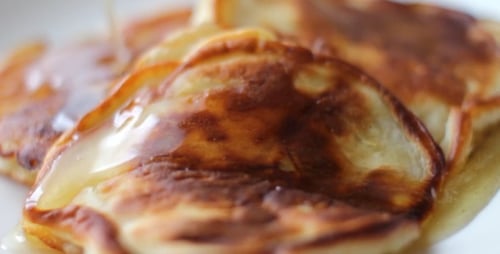 Pancakes Drenched in Golden Syrup on Plate