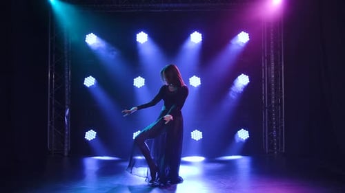 Trendige junge Frau tanzt Single im Club, Neonlicht, Viel Rauch. Modische Streetwear