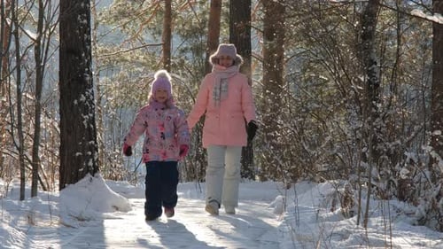 Woman and Child Walking in Winter Forest