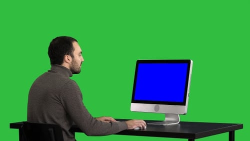 Man typing on the computer on a Green Screen Chroma Key.
