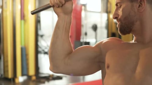 Male Doing Front Pull-Downs in Gym and Enjoying View of His Large Biceps