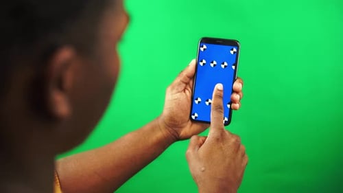 Black Man Holds Smartphone with Tracking Markers Display and Swiping Left Then Tap on Touch Screen