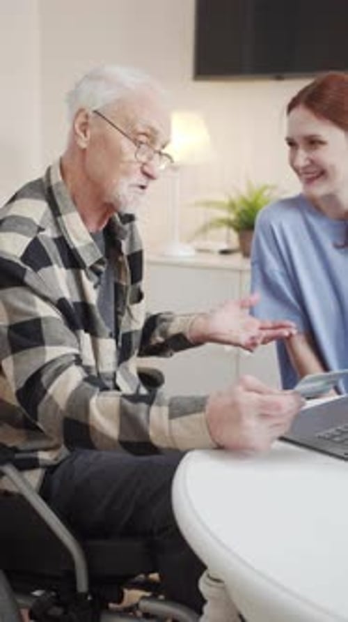 Senior Man Shopping Online with Young Adult Woman