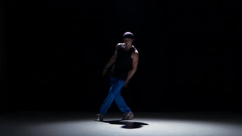 Junger Tänzer tanzt Breakdance auf Schwarz