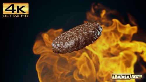 Hamburger Patty Spinning with Flames on a Dark Background