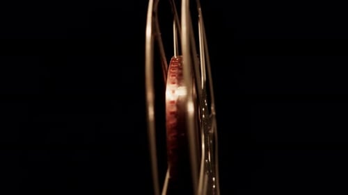 Vintage Golden Film Reel Rotating on Black