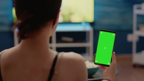 Joven con pantalla verde vertical en el teléfono inteligente