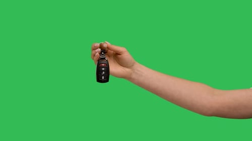 Female Hand Holding Car Remote Control Points His Finger at It and Makes Thumb Up Recommendation