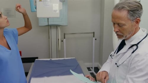 Doctor and Nurse Discussing Patient Case in Hospital Room