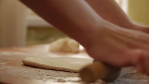 Woman Rolling Out Dough in the Kitchen