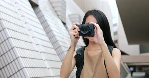 Young Woman Taking Pictures with Digital Camera Outdoors