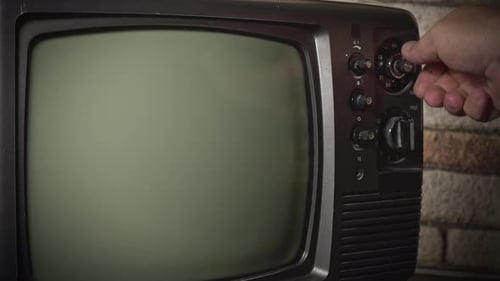 Hand Turns the Dial of an Old Television