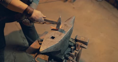 Blacksmith Shaping Red Hot Metal with Hammer