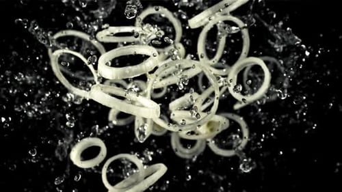 Macro Footage of Sliced Onions Splashing with Water