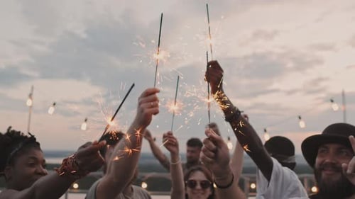Happy People Holding Sparklers at Rooftop Party