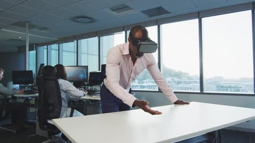 African American businessman wearing VR headset in modern office