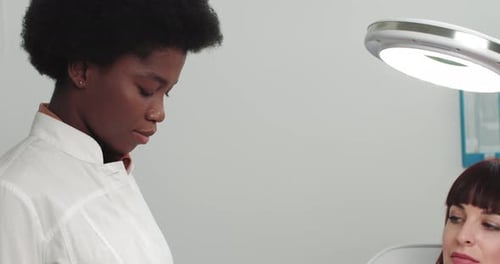 Cosmetologist Examines Patient's Wrist in Modern Hospital