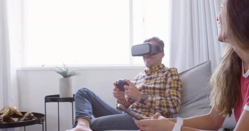 Man Plays VR Game While Woman Uses Phone