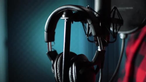 Closeup Hands of Singer Taking Off Headphones of Rack for Microphone at Music Record Studio
