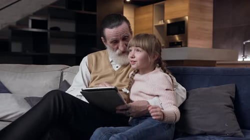 Grandfather and Granddaughter Bonding with Tablet at Home