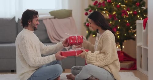 Couple Exchanging Christmas Gifts in Cozy Home