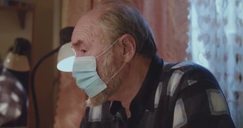 Senior Adult Wearing Protective Face Mask Indoors