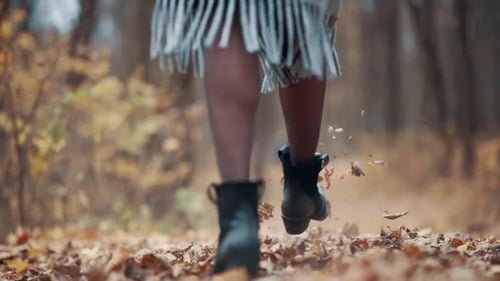 Woman Walking Through Colorful Autumn Leaves