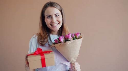 Smiling Woman Holding Roses and Gift Box Present