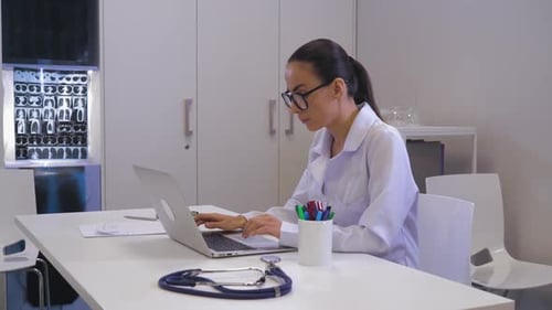 Young Doctor Working at Computer in Office