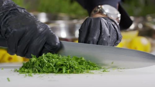 Chef Chopping Green Herbs with a Knife