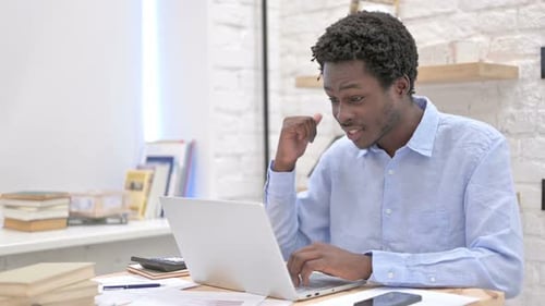 Young Man Video Conferencing on Laptop in Office