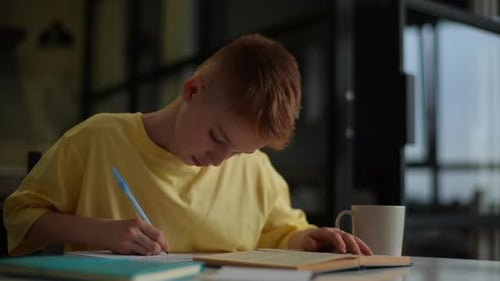 Child Studying and Writing in a Notebook
