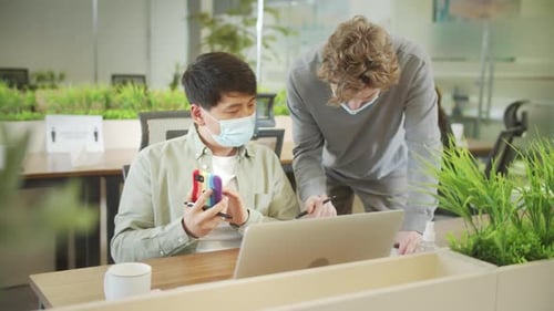 Un jeune collègue vient voir son partenaire avec des questions pendant qu'il téléphone