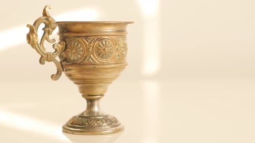 Ornate Gold Antique Cup on White Surface