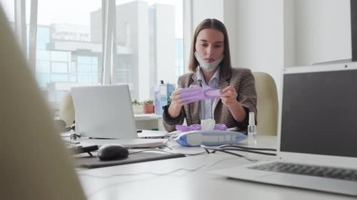 Young Woman Using Sanitizer in Office