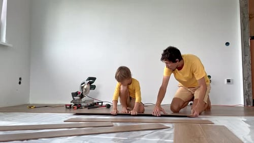 Father and Child Installing Laminate Flooring Together