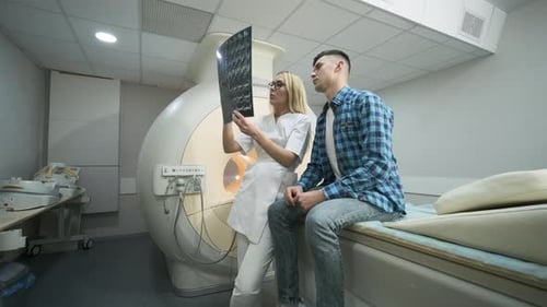 Doctor Examining X-ray with Patient in Hospital Room