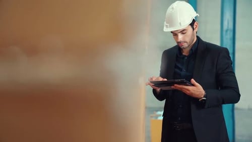 Factory Manager Using Tablet Computer in Warehouse or Factory