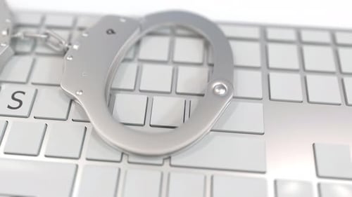Handcuffs and Keyboard Reveal VIRUS Word for Cybercrime
