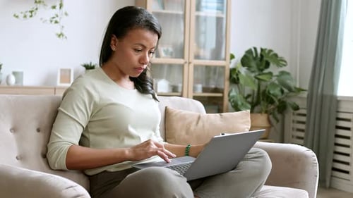 Woman Uses Laptop and Credit Card at Home