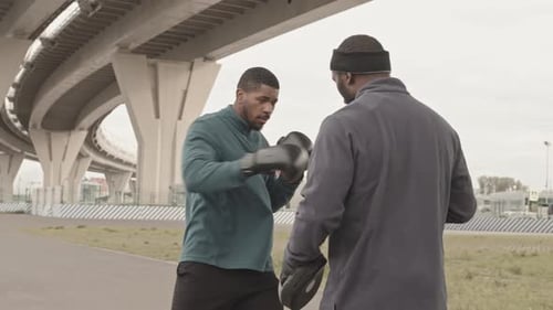 Man Boxing and Training with Coach Outdoors
