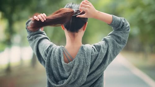 Young asian sport woman tie hair making ponytail ready to exercise in public park