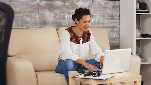 Woman Video Conferencing at Home on Laptop