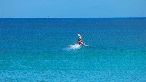 Boat Drifting Across the Tropical Blue Waters