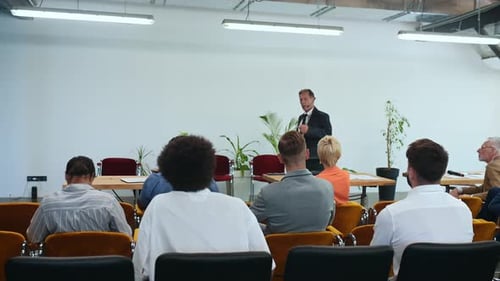 Man Giving Corporate Presentation to Audience Indoors