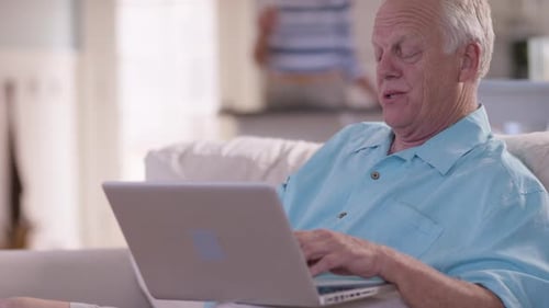 Senior Man Typing on Laptop at Home